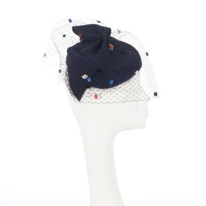 Nerida Fraiman - Asymmetric navy blue blocked beret in open weave straw with giant bow and multi colour spot veil